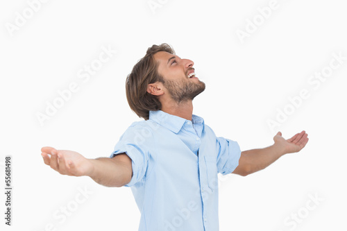 Photo: Happy man looking up with arms outstretched Happy man looking up with arms outstretched