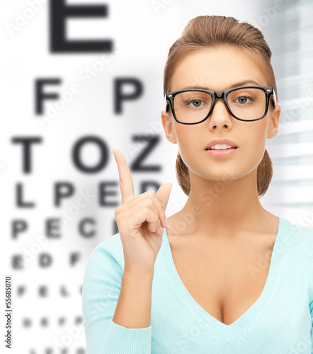Photo: woman in eyeglasses with eye chart woman in eyeglasses with eye chart