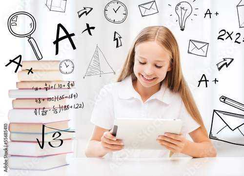 Photo: girl with tablet pc and books at school girl with tablet pc and books at school