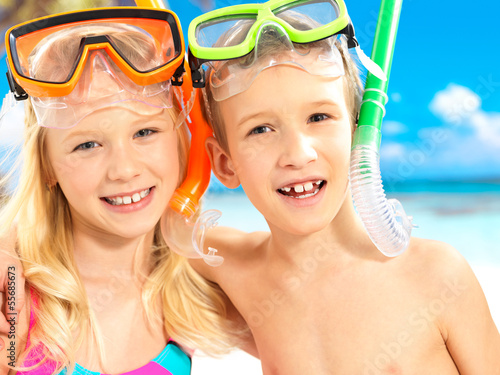 Photo: Portrait of the happy children enjoying at beach Portrait of the happy children enjoying at beach