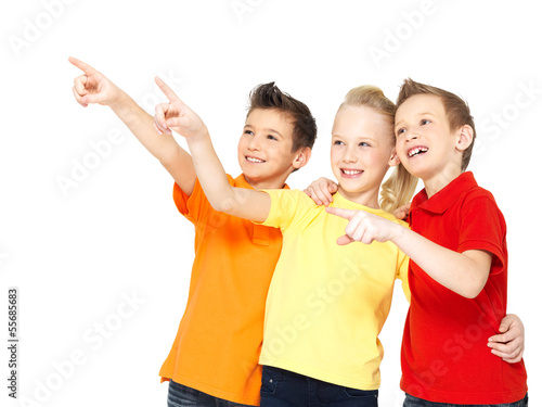 Photo: Happy children point by finger on something away. Happy children point by finger on something away.