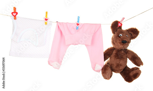 Photo: Baby clothes hanging on clothesline, isolated on white Baby clothes hanging on clothesline, isolated on white
