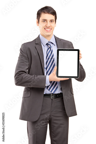Photo: Smiling businessman in suit showing a tablet Smiling businessman in suit showing a tablet