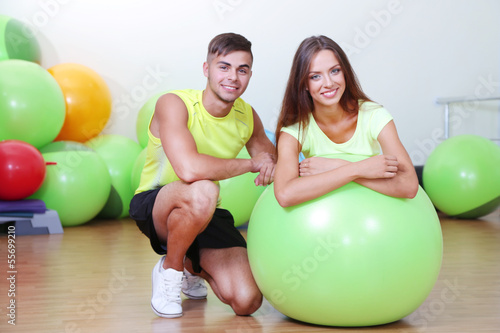 Photo: Girl and guy in fitness room Girl and guy in fitness room