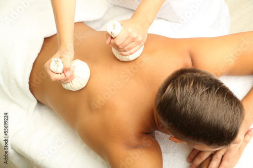 Photo: Young man having back massage close up Young man having back massage close up
