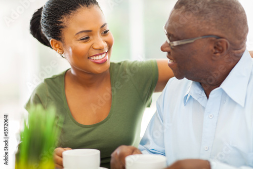 Photo: elderly african american man enjoying coffee with his granddaugh elderly african american man enjoying coffee with his granddaugh