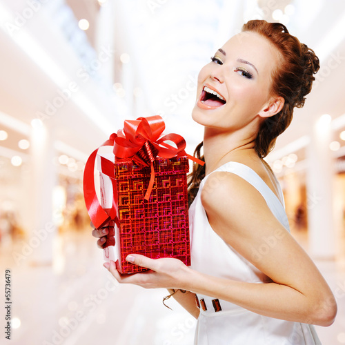 Photo: Happy young woman with birthday present in hands Happy young woman with birthday present in hands