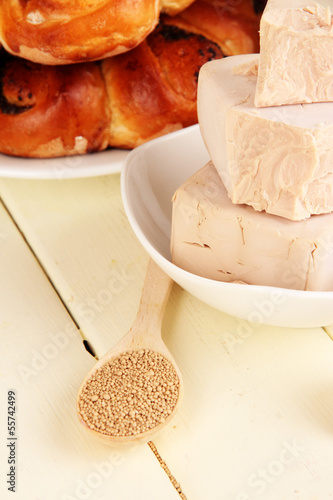 Photo: Dry yeast with pastry on wooden table close-up Dry yeast with pastry on wooden table close-up