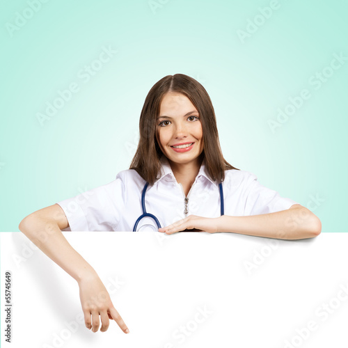 Photo: young woman doctor with a blank banner young woman doctor with a blank banner