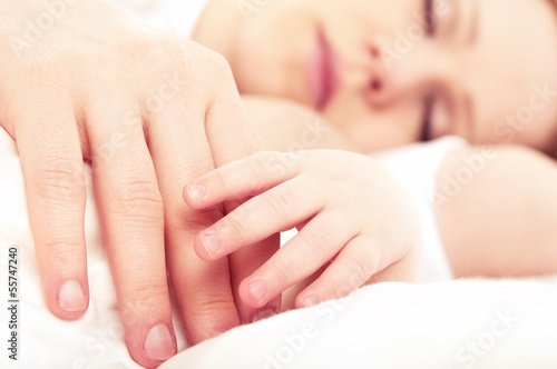 Photo: hand the sleeping baby in the hand of mother hand the sleeping baby in the hand of mother