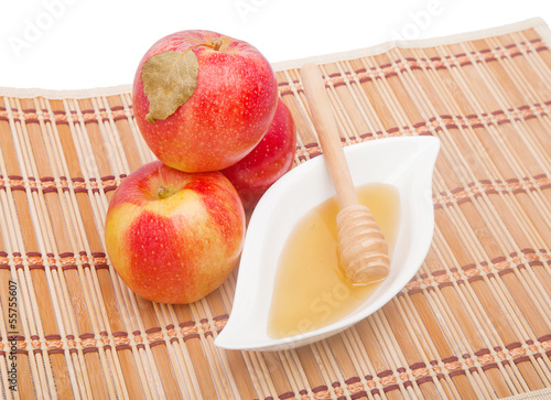Photo: Pyramid of red apples and honey in gravy boat Pyramid of red apples and honey in gravy boat