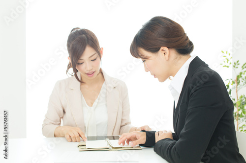 Photo: Beautiful young businesswomen working in the office Beautiful young businesswomen working in the office