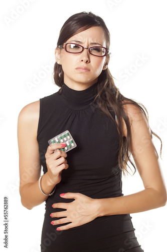 Photo: woman has pain in his stomach and holding pills in her hand woman has pain in his stomach and holding pills in her hand
