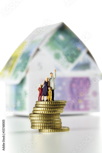 Photo: Figuren auf Münzen vor dem Haus aus Euro-Banknoten Figuren auf Münzen vor dem Haus aus Euro-Banknoten
