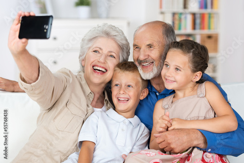 Photo: großeltern fotografieren die familie mit handy großeltern fotografieren die familie mit handy