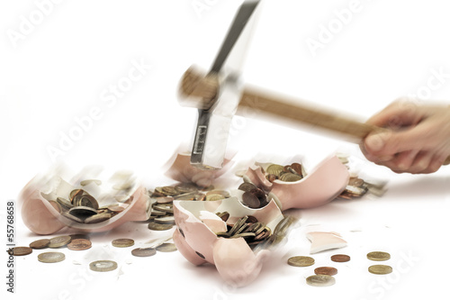 Photo: Hammer zerschlägt Sparschwein mit Euro-Münzen, Nahaufnahme Hammer zerschlägt Sparschwein mit Euro-Münzen, Nahaufnahme