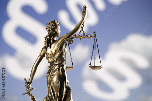 Photo: Justizia Figur vor Paragraphen, Rückansicht, Nahaufnahme Justizia Figur vor Paragraphen, Rückansicht, Nahaufnahme