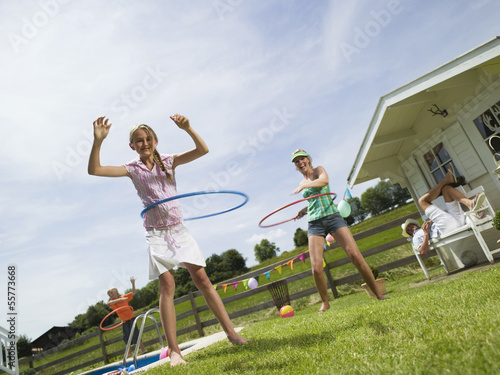 Photo: Familie im Garten, Spiel mit Hula-Hoop-Reifen Familie im Garten, Spiel mit Hula-Hoop-Reifen