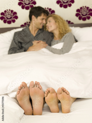 Photo: Junges Paar im Bett liegend, Nahaufnahme der Füße Junges Paar im Bett liegend, Nahaufnahme der Füße