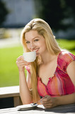 Foto: Deutschland, Bayern, Oberbayern, junge Frau mit einer Tasse Kaffee in Biergarten, Portrait Deutschland, Bayern, Oberbayern, junge Frau mit einer Tasse Kaffee in Biergarten, Portrait