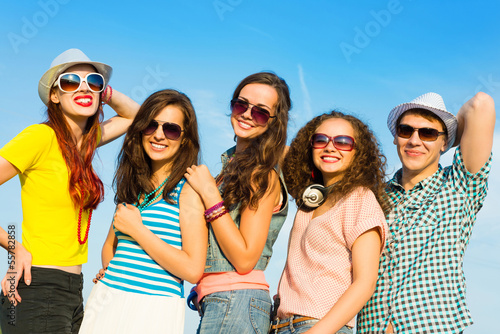 Photo: group of young people wearing sunglasses and hat group of young people wearing sunglasses and hat