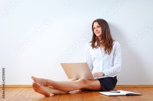 Photo: Young beauty with laptop sitting on the floor. Young beauty with laptop sitting on the floor.