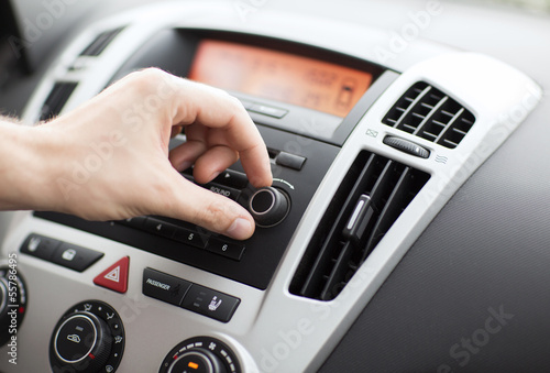Photo: man using car audio stereo system man using car audio stereo system