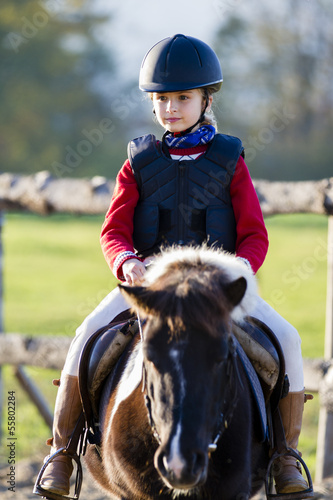 Photo: Horse riding - lovely girl is riding on a horse Horse riding - lovely girl is riding on a horse