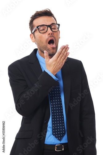 Photo: Sleepy businessman covering mouth and yawning Sleepy businessman covering mouth and yawning