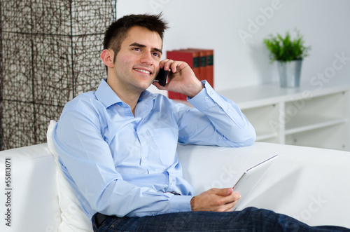 Photo: freundlicher mann am telefon mit tablet freundlicher mann am telefon mit tablet