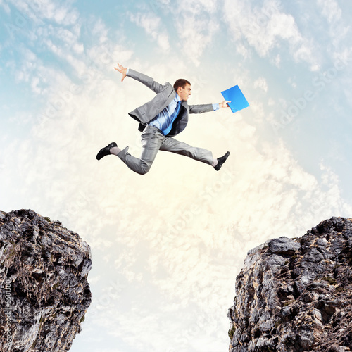 Photo: Businessman jumping over gap Businessman jumping over gap