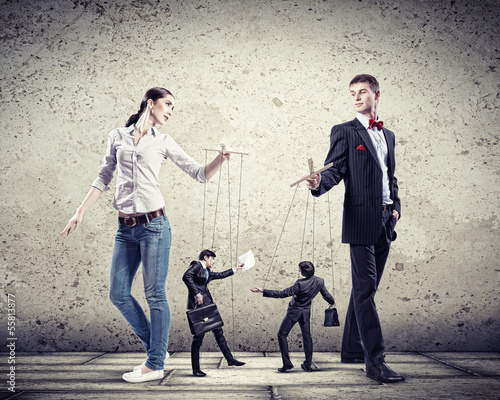 Photo: Businesspeople with marionettes Businesspeople with marionettes