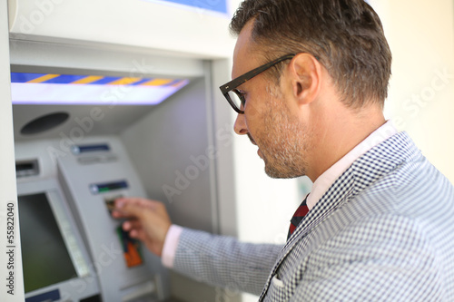 Photo: Man withdrawing money from ATM machine Man withdrawing money from ATM machine