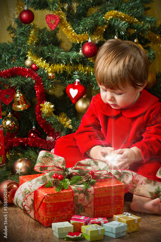 Photo: baby play with present box at Christmas tree baby play with present box at Christmas tree