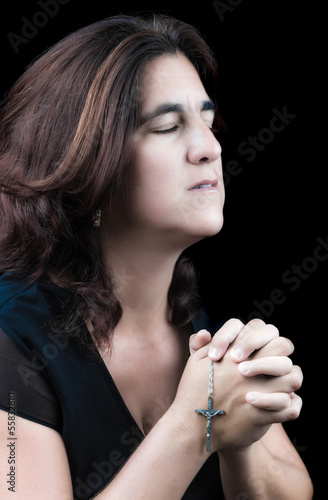 Photo: Hispanic woman praying with her eyes closed Hispanic woman praying with her eyes closed