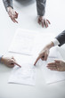 Photo: Four business people arguing and gesturing around a table during a business meeting, hands only Four business people arguing and gesturing around a table during a business meeting, hands only