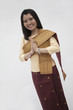Photo: Portrait of smiling young woman with hands clasped together in traditional clothing from Laos, studio shot Portrait of smiling young woman with hands clasped together in traditional clothing from Laos, studio shot