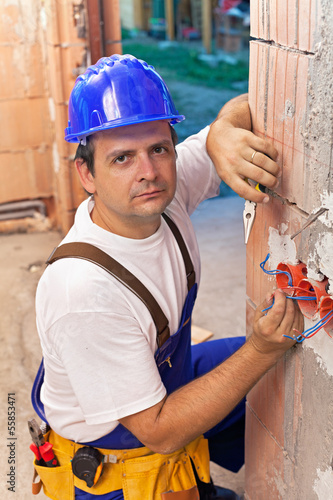 Photo: Electrician installing wires in a new building Electrician installing wires in a new building