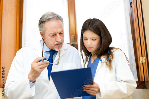 Photo: Portrait of a doctor and his assistant in his studio Portrait of a doctor and his assistant in his studio