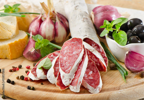 Photo: Salami sliced on wooden table Salami sliced on wooden table