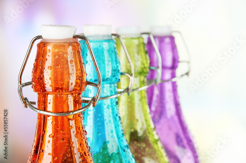 Photo: Colorful bottles on bright background Colorful bottles on bright background