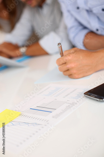 Photo: Man's hand holding pen in business meeting Man's hand holding pen in business meeting