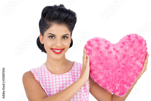 Photo: Lovely black hair model holding a pink heart shaped pillow Lovely black hair model holding a pink heart shaped pillow
