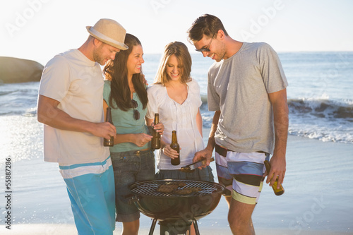 Photo: Cheerful young friends having barbecue together Cheerful young friends having barbecue together