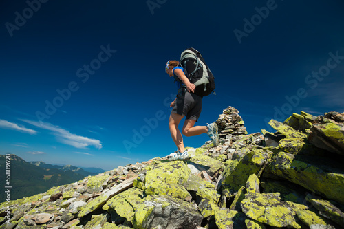 Photo: Hiker jumps over stones in mountains Hiker jumps over stones in mountains