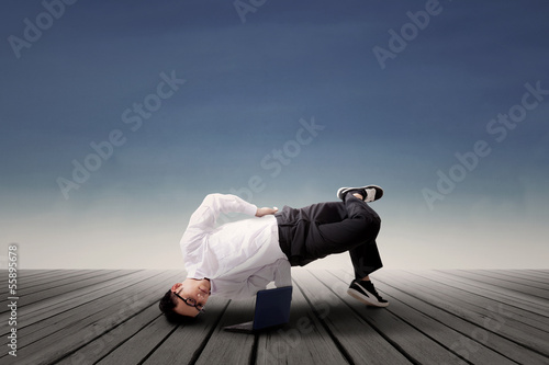 Photo: Businessman dancing and looking at laptop Businessman dancing and looking at laptop