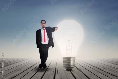 Photo: Businessman with lit bulb outdoor Businessman with lit bulb outdoor