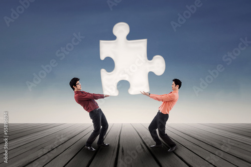Photo: Two businessmen bring puzzle outdoor Two businessmen bring puzzle outdoor