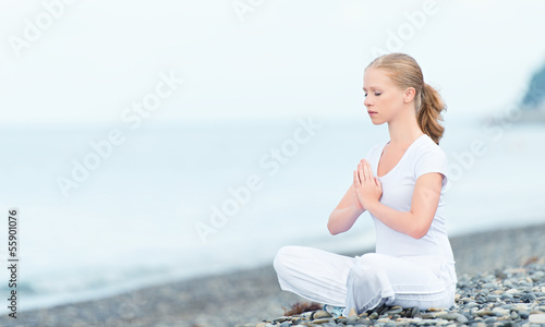 Photo: woman meditating in lotus yoga on beach woman meditating in lotus yoga on beach