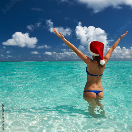 Photo: Woman in santa's hat at beach Woman in santa's hat at beach